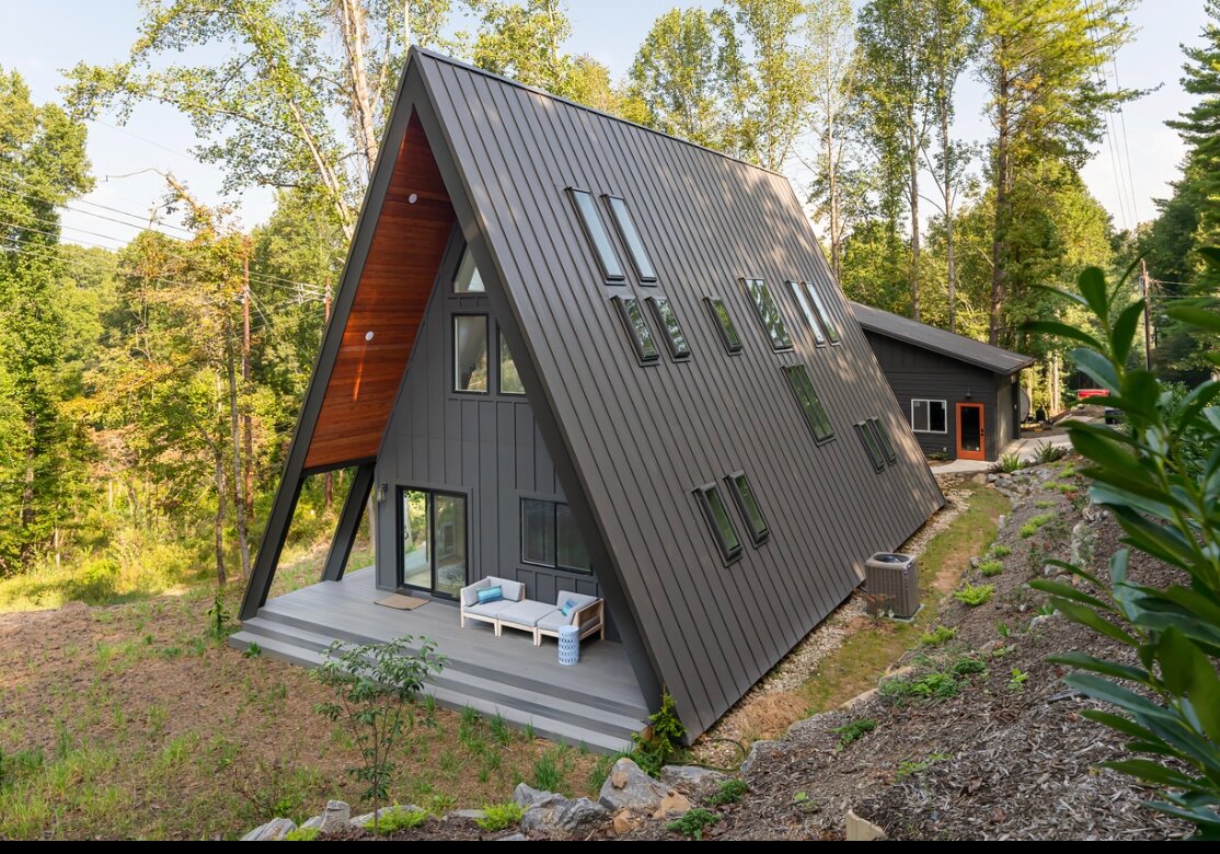 Standing-seam metal roof sweeping to ground level